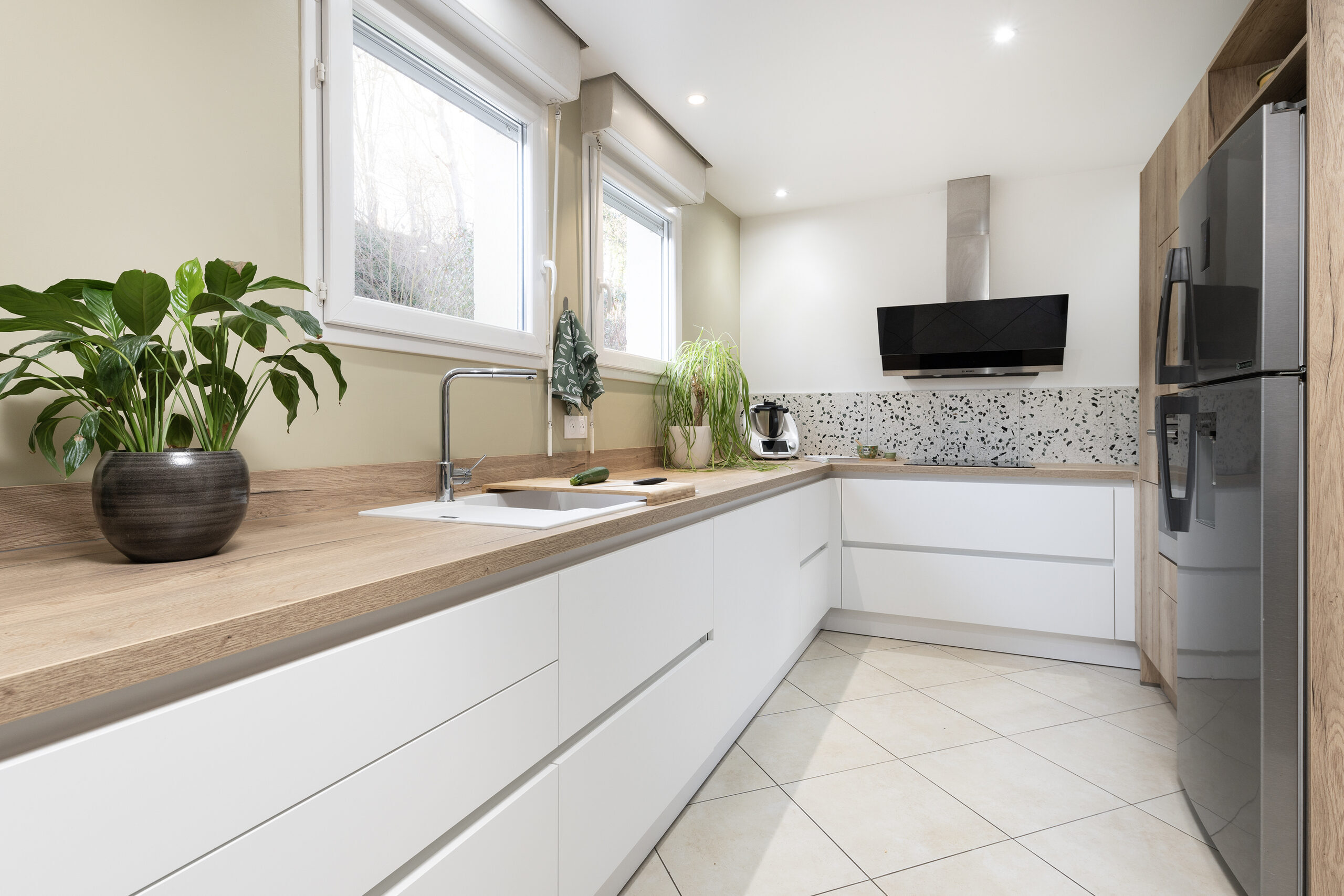 Cuisine Longue blanche : le motif moucheté marque le fond de cuisson, à côté du décor aspect bois.