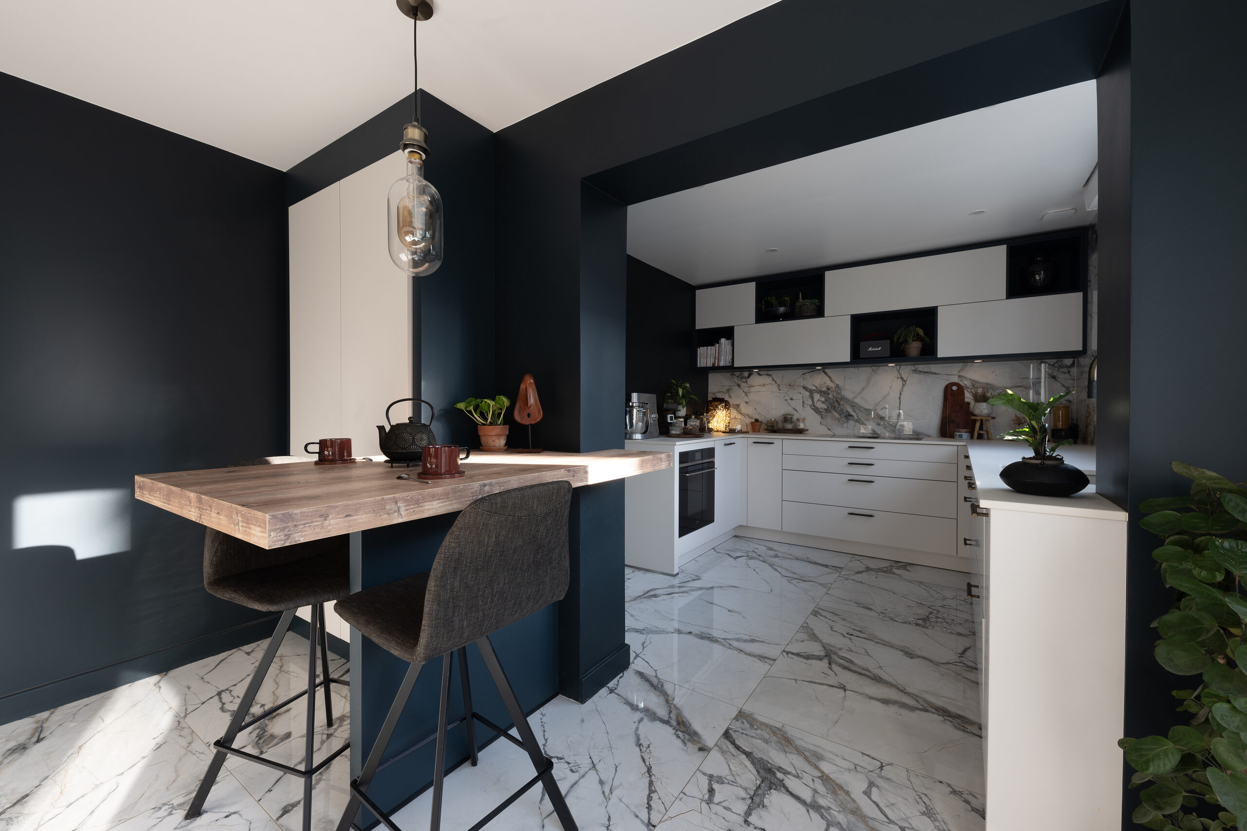 Cuisine Blanc noir : le plateau repas est distinct du plan de travail de la cuisine.
